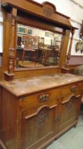 An early 20th century mirror backed sideboard having bevel glass mirror to back, the base having two