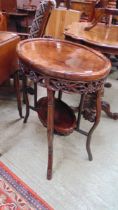 A Chinese inspired oval top table with under tier Damages to both sides to underside of top.