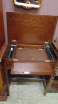 A mid-20th century oak writing desk with lift up lid concealing fold over writing surface with glass