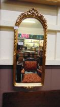 A small ornate gilt framed arch topped mirror