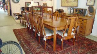 A Chinese hardwood extending dining table with two centre leaves together with a set of eight