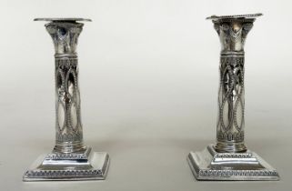 CANDLESTICKS, a pair, George V silver with swag decorated columns and square bases Sheffield 1928