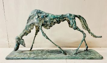 GIACOMETTI STYLE SCULPTURE OF A DOG, bronze with verdigris finish, raised on a plinth base. 59.5cm L