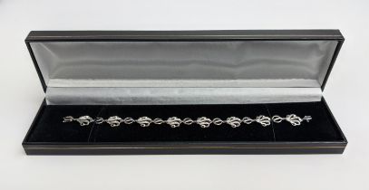 A 9CT WHITE GOLD DIAMOND BRACELET, wave-form, fitted with round cut diamonds totalling 0.20