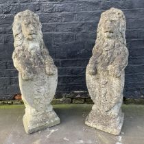 HERALDIC LION STATUES, a pair, well weathered reconstituted stone, 83cm. (2)