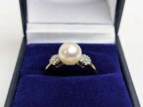 A 9CT GOLD SINGLE CULTURED PEARL SET DRESS RING, with daisy set diamond cluster shoulders, the