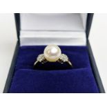 A 9CT GOLD SINGLE CULTURED PEARL SET DRESS RING, with daisy set diamond cluster shoulders, the