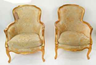 BERGERES, a pair, each 68cm x 93cm H with gilt showframes and gold patterned upholstery. (2)