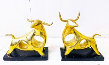 SCULPTURAL CAST BRONZE BULLS, a set of two, each raised on black marble bases, 19cm high, 25cm wide,