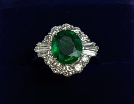 AN 18CT WHITE GOLD EMERALD AND DIAMOND CLUSTER RING, the oval stone of approx. 1.89 carats,