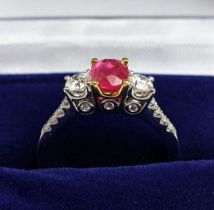 AN 18CT WHITE GOLD RUBY AND DIAMOND TRILOGY RING, the central ruby stone of approx. 0.89 carat,