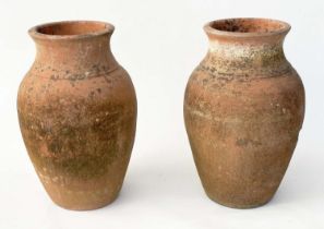 TERRACOTTA URNS, a pair, vintage weathered terracotta of vase form, 53cm H. (2)