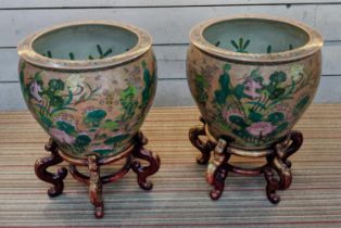 PLANTERS ON STANDS, a pair, Chinese style ceramic, wooden stands, 72cm H x 55cm diam approx. (2)