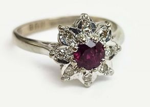 AN 18CT WHITE GOLD RUBY AND DIAMOND DRESS RING, flower head setting, the central ruby of