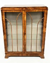 ART DECO DISPLAY CASE, figured walnut with two arched glazed panelled doors enclosing glass shelves,