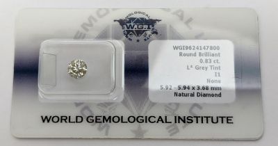 A ROUND BRILLIANT CUT LOOSE DIAMOND, of 0.83 carat, grey tint, complete with certificate and