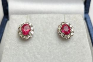 A PAIR OF 18CT WHITE GOLD RUBY AND DIAMOND STUD EARRINGS, each with a single faceted ruby of