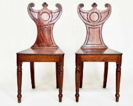 HALL CHAIRS, a pair, George III period mahogany with carved crescent backs and solid panel seat