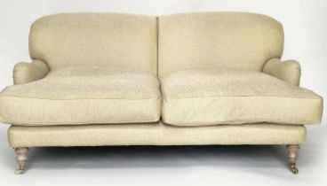 HOWARD STYLE SOFA, three seater with rounded back, scroll arms and turned supports with natural