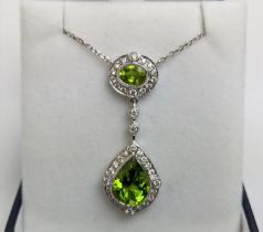 AN 18CT WHITE GOLD PERIDOT AND DIAMOND SET PENDANT NECKLACE, the pear shaped drop pendant surrounded