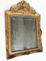WALL MIRROR, late 18th century French carved giltwood and gesso with foliate crest and distressed