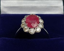 AN 18CT WHITE GOLD RUBY AND DIAMOND CLUSTER RING, the central ruby of approx. 1.87 carats,