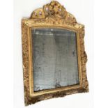 WALL MIRROR, late 18th century French carved giltwood and gesso with foliate crest and distressed