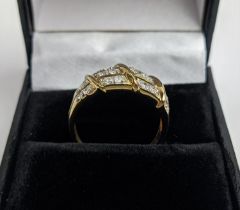 A 9CT GOLD AND DIAMOND SET DRESS RING, set with three rows of diamonds in sectional form, the