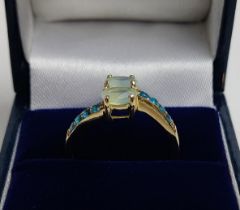 A 9CT GOLD PREHNITE AND NEON APATITE CROSSOVER RING, to the shoulders, ring size P, boxed.