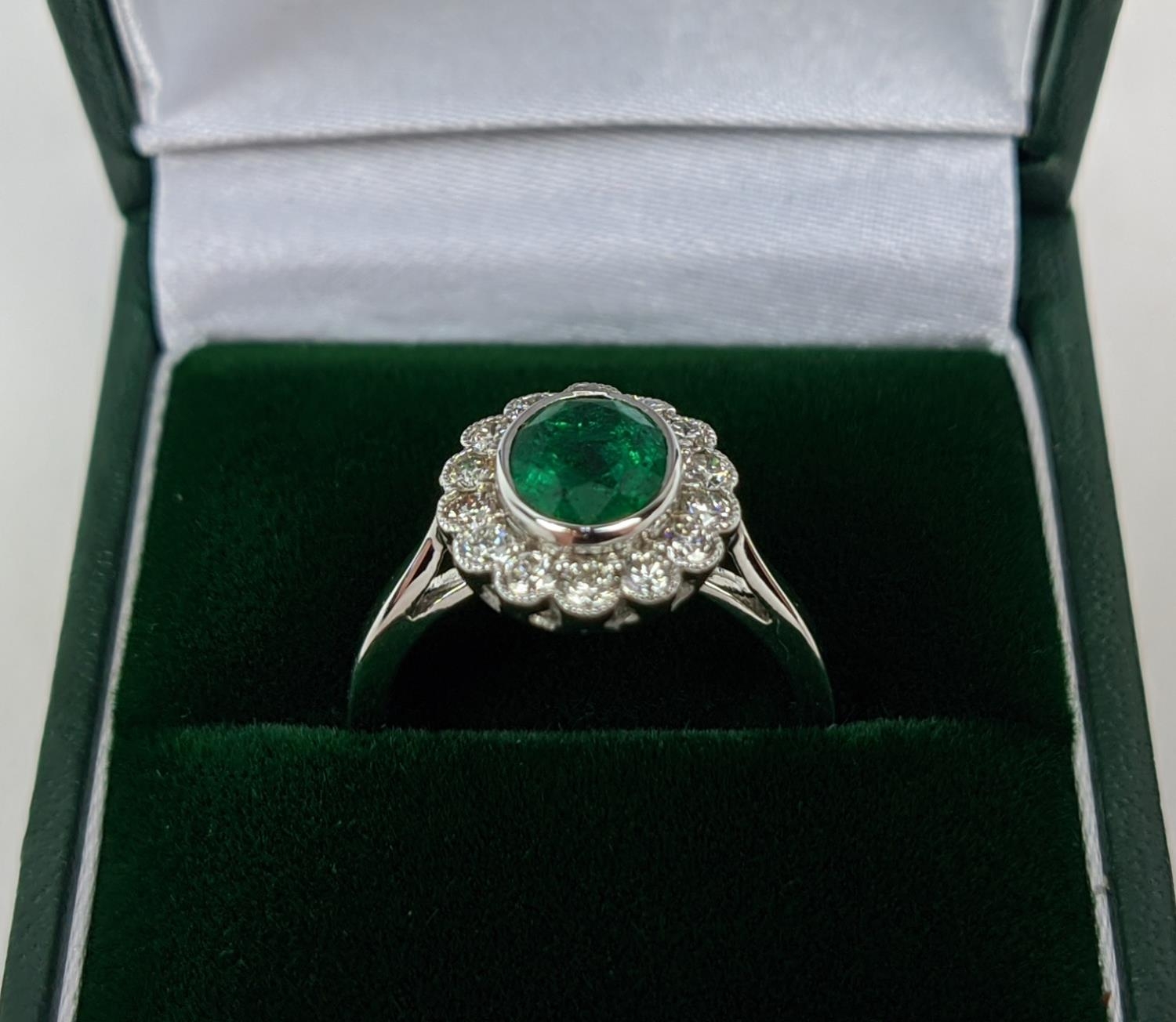 AN 18CT WHITE GOLD EMERALD AND DIAMOND DRESS RING, the central emerald of approximately 1.60 carats,