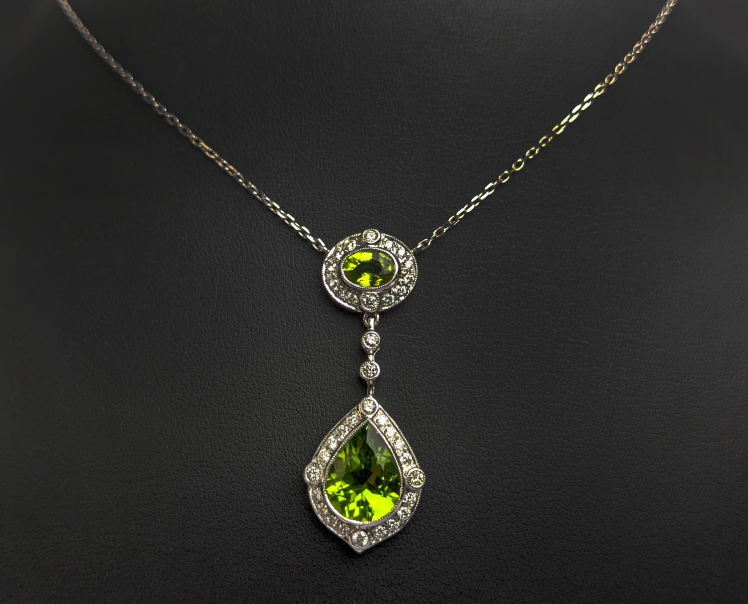 AN 18CT WHITE GOLD PERIDOT AND DIAMOND SET PENDANT NECKLACE, the pear shaped drop pendant surrounded