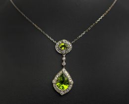 AN 18CT WHITE GOLD PERIDOT AND DIAMOND SET PENDANT NECKLACE, the pear shaped drop pendant surrounded