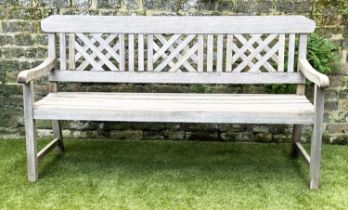 GARDEN BENCH, well weathered silvery teak of slatted construction with lattice panelled back,