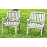 GARDEN ARMCHAIRS, a pair, well weathered teak of slatted construction, 58cm W. (2)