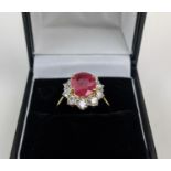 AN 18CT GOLD RUBY AND DIAMOND CLUSTER RING, the mixed cut ruby of 4.11 carats, surrounded by ten