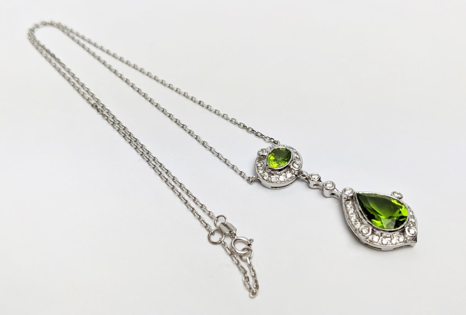 AN 18CT WHITE GOLD PERIDOT AND DIAMOND SET PENDANT NECKLACE, the pear shaped drop pendant surrounded - Image 8 of 10