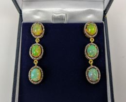 A PAIR OF SILVER-GILT OPAL AND DIAMOND SET PENDANT EARRINGS, of triple sectioned droplet form,