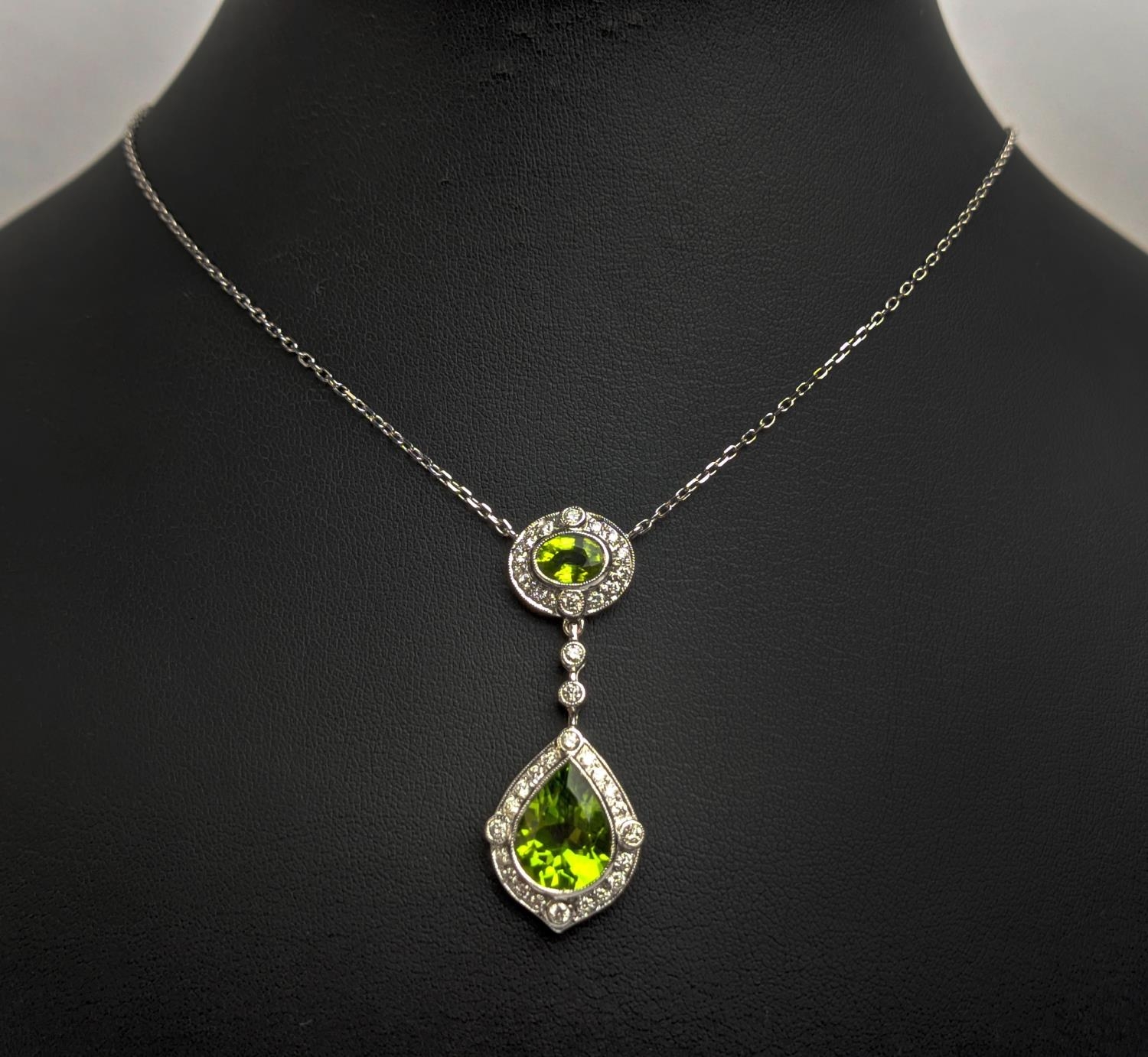 AN 18CT WHITE GOLD PERIDOT AND DIAMOND SET PENDANT NECKLACE, the pear shaped drop pendant surrounded - Image 6 of 10