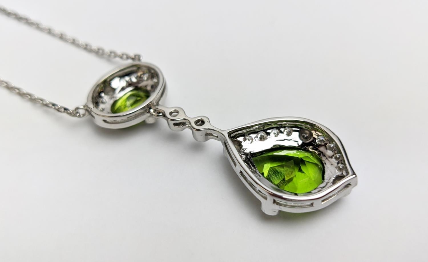 AN 18CT WHITE GOLD PERIDOT AND DIAMOND SET PENDANT NECKLACE, the pear shaped drop pendant surrounded - Image 9 of 10