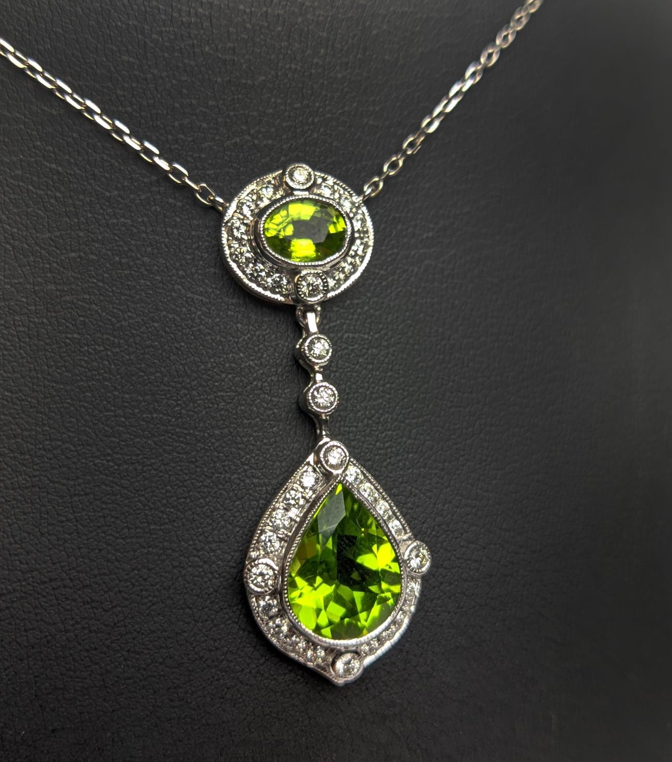 AN 18CT WHITE GOLD PERIDOT AND DIAMOND SET PENDANT NECKLACE, the pear shaped drop pendant surrounded - Image 7 of 10