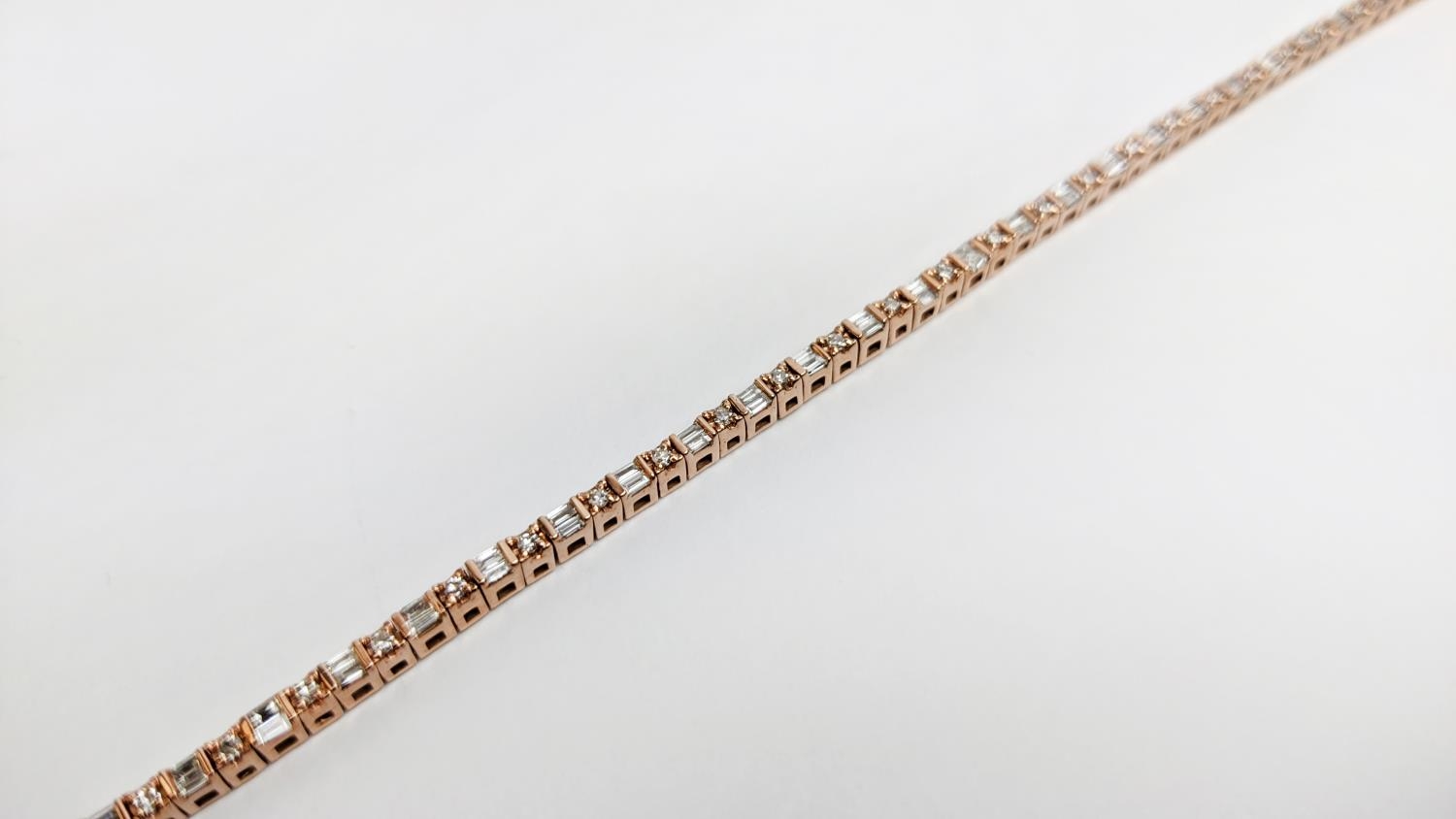 A 10CT ROSE GOLD AND DIAMOND SET BRACELET, set with alternating baguette and round brilliant cut - Image 7 of 9