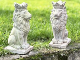 GARDEN LIONS, a pair, weathered reconstituted stone each seated and crowned, 35cm H. (2)