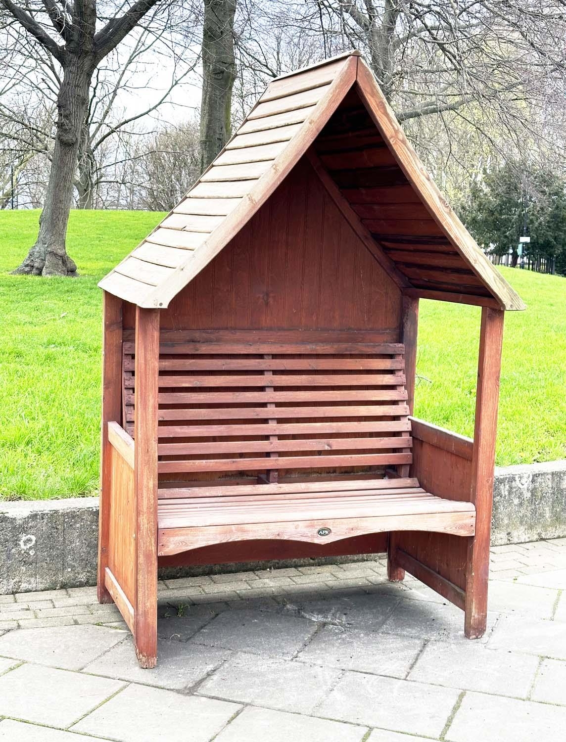 ARBOUR SEAT, traditional form well weathered treated softwood with slatted seat and boarded gable