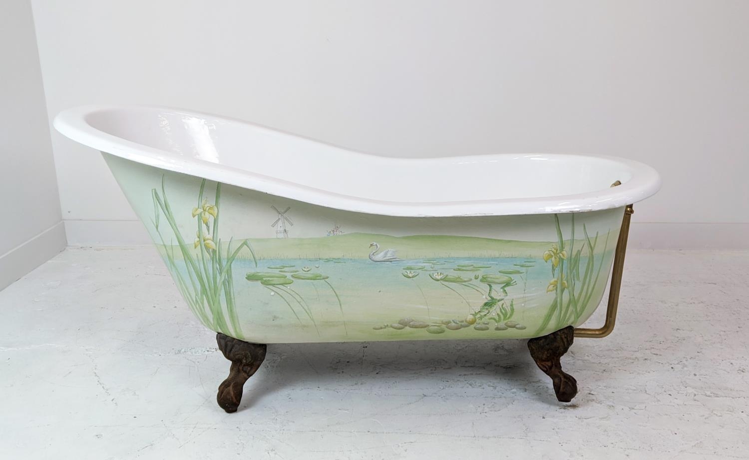 CAST IRON SLIPPER BATH, on ball and claw feet with one side having a painted riperian scene