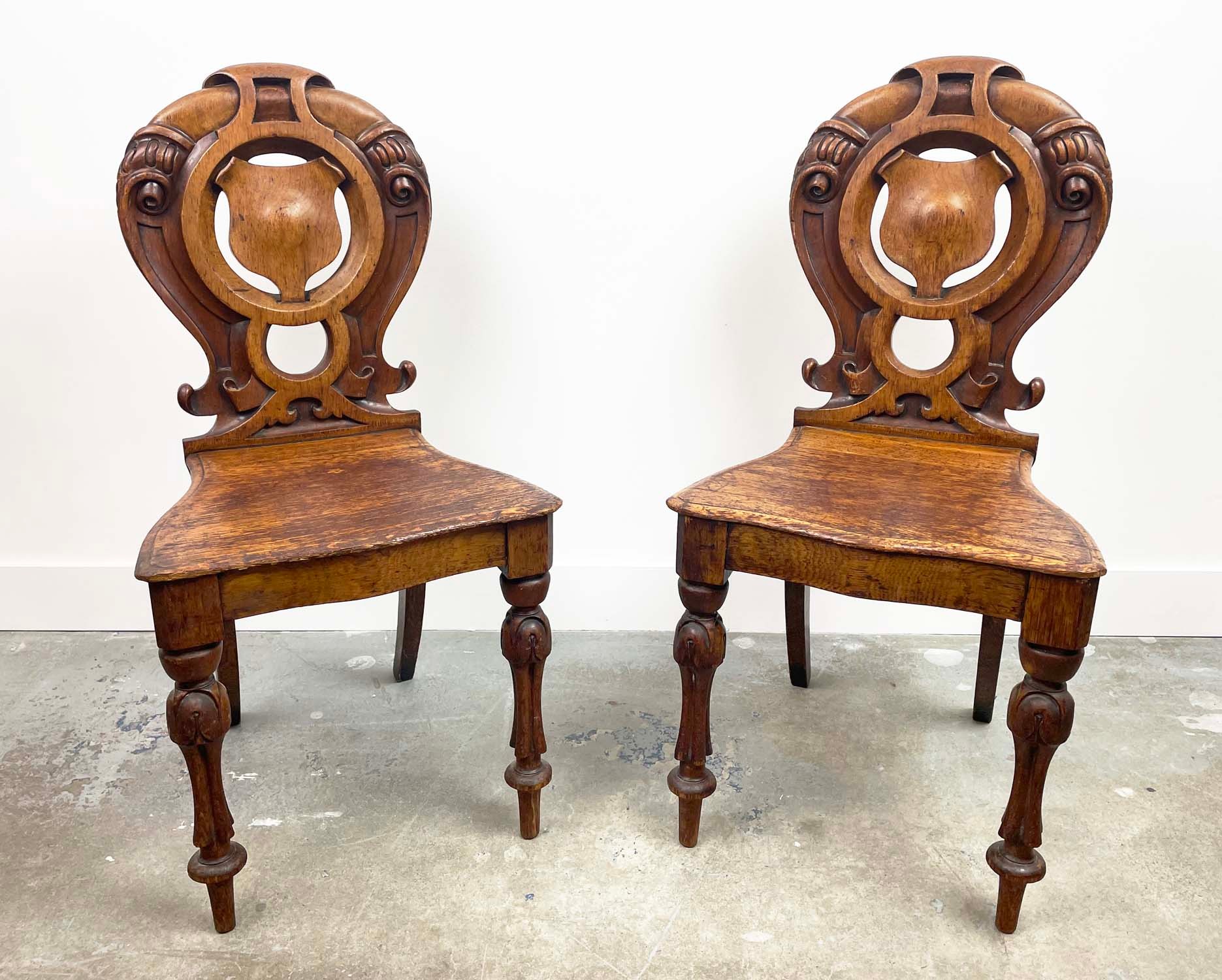 HALL CHAIRS, a pair, Victorian oak, with ornately carved and pierced backs. (2)