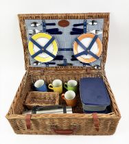 G.T.C. PICNIC BASKET, four place setting, including plates, cutlery, mugs, flask and tuperware in