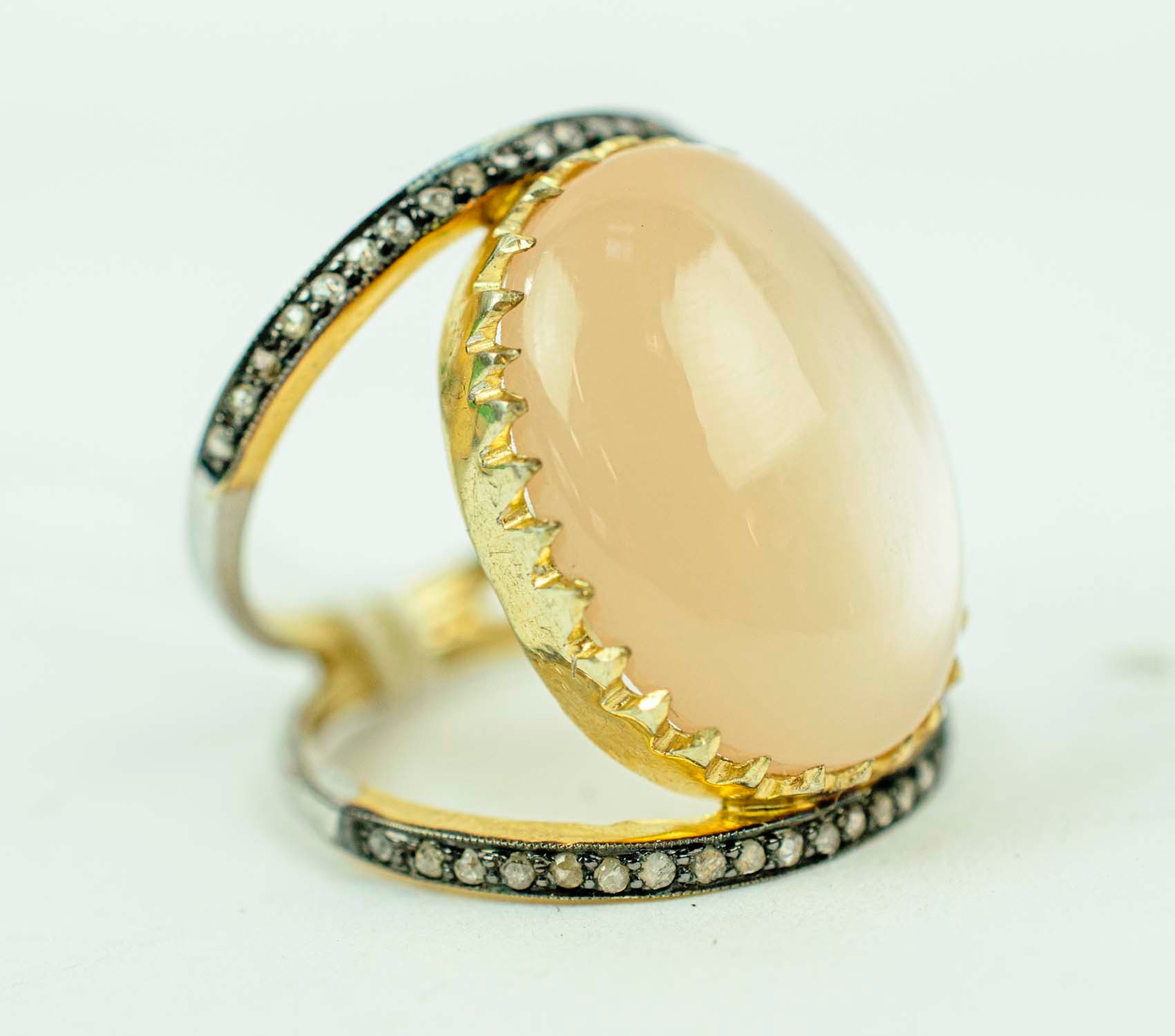 A CABOUCHON AND DIAMOND DRESS RING, set with a moonstone coloured cabouchon of approximately 14.70