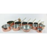 BATTERIE DE CUISINE, a graduated set of twelve, copper pans, with brass handles. (12)