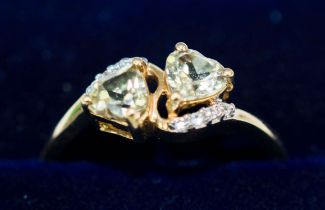 A 9CT GOLD QUARTZ AND DIAMOND SET DRESS RING, set with two heart shaped quartz stones and diamond