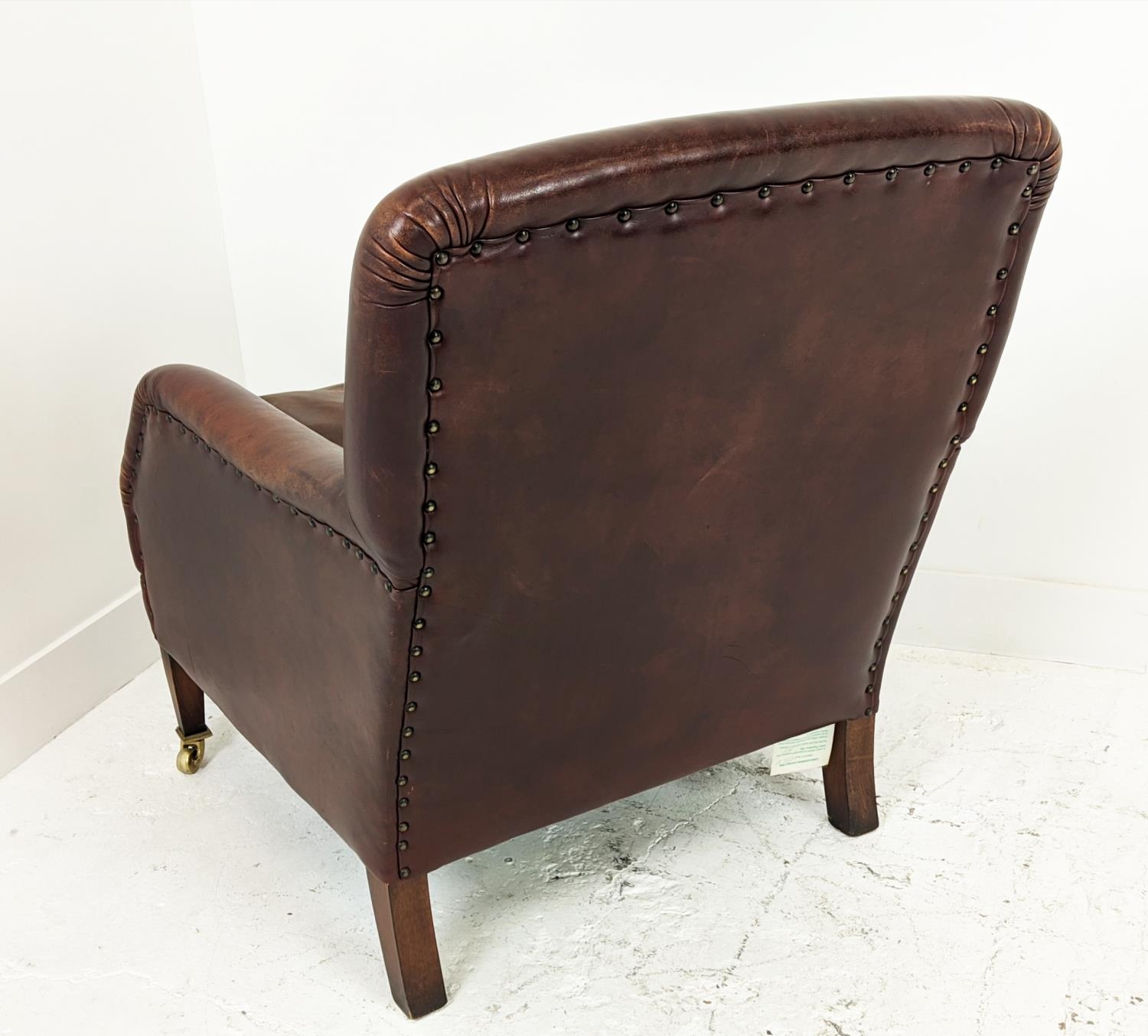 LIBRARY ARMCHAIR, studded tan leather raised on brass castors, 84cm H x 68cm W. - Image 9 of 9